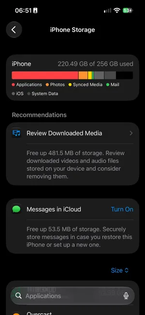 Settings, General, iPhone Storage on iOS 27: iPhone 220.49 GB of 256 GB used, a bar split into Applications, Photos, Synced Media, Mail, iOS and System Data, then Recommendations: Review Downloaded Media to free up 481.5 MB, and Messages in iCloud to free up 53.5 MB
